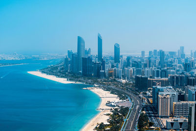 High angle view of buildings by sea against sky