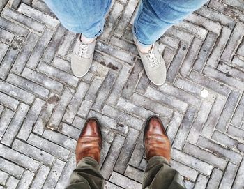 Low section of people standing on cobbled street