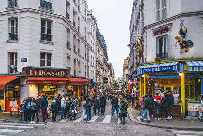 People walking on street against buildings in city