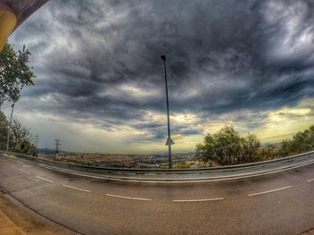 Street by road against storm clouds