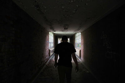 Rear view of silhouette man walking in tunnel