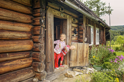 Portrait of boy standing outside house