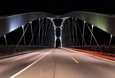 View of bridge at night with light streak