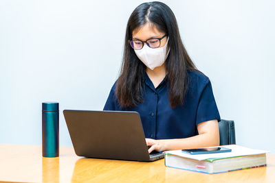 Young woman using mobile phone on table