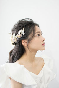 Close-up of young woman against white background