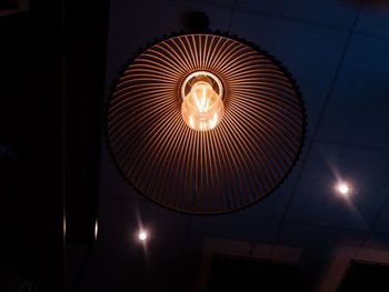 Low angle view of illuminated lighting equipment hanging on ceiling