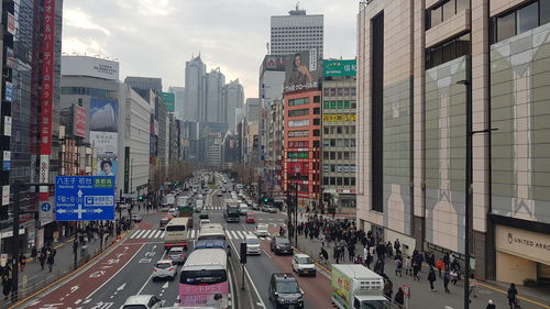 Traffic on city street amidst buildings against sky