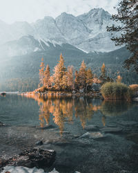 Scenic view of lake by snowcapped mountains against sky