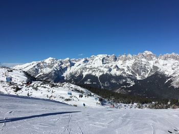 Scenic view of snowcapped mountains against clear blue sky