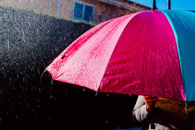 Close-up of wet pink umbrella on street