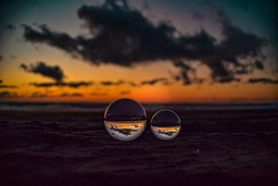 Close-up of sunglasses on beach during sunset