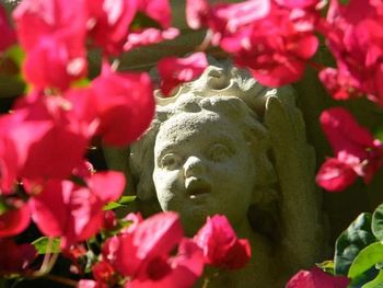 Close-up of pink statue amidst flowering plants