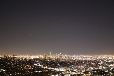 High angle view of illuminated buildings against clear sky at night