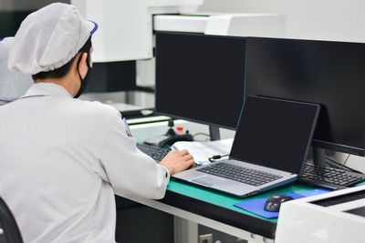 Midsection of man using laptop at office