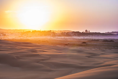 Scenic view of beach against sky during sunset