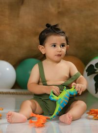 High angle view of cute baby boy sitting on field