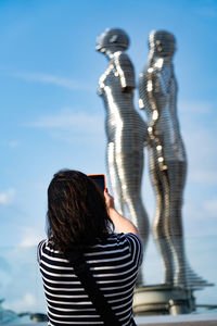 Rear view of woman standing against sky