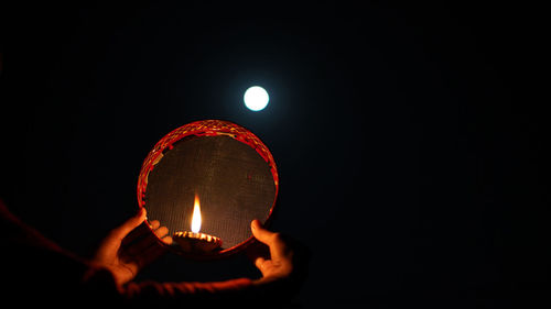 Close-up of illuminated light bulb against black background