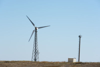 Low angle view of windmill on field against clear sky