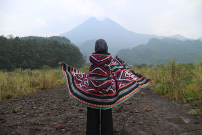 Rear view of woman with scarf standing on land