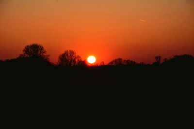 Scenic view of silhouette landscape against orange sky