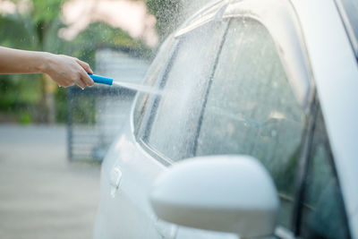 Cropped hand of person washing car