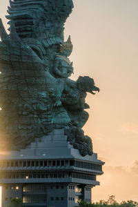 Statue of historic building against sky during sunset