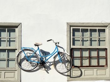 Side view of bicycle against white building