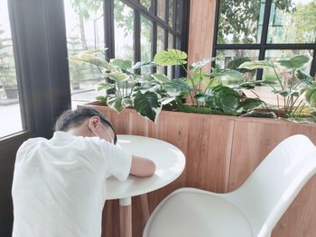 Man relaxing on table by window