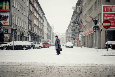 Man walking on street in city during winter