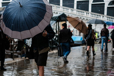 People walking with umbrella on wet rainy season in city during monsoon