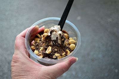 Close-up of person holding ice cream sundae