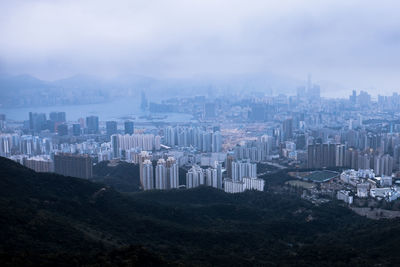 Aerial view of buildings in city against sky