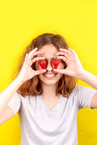 Portrait of smiling girl with ice cream against yellow background