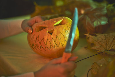 Close-up of hand holding pumpkin