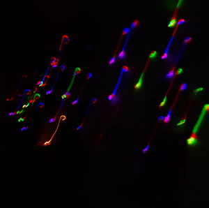 Close-up of illuminated lighting equipment against black background