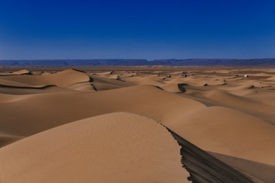 Scenic view of desert against clear blue sky