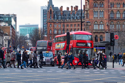 People on street against buildings in city