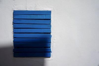 Close-up of blue window on white wall