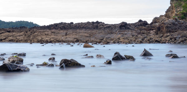 Rocks in sea against sky