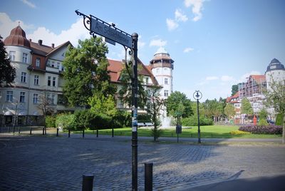 Street by buildings in city against sky