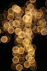 Low angle view of illuminated lights against black background