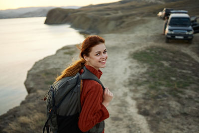 Portrait of smiling young woman standing on land