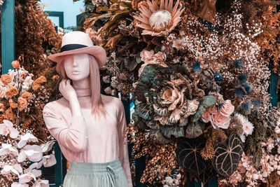 Mannequin against flowering plants