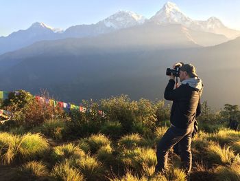 Rear view of woman photographing on mountain