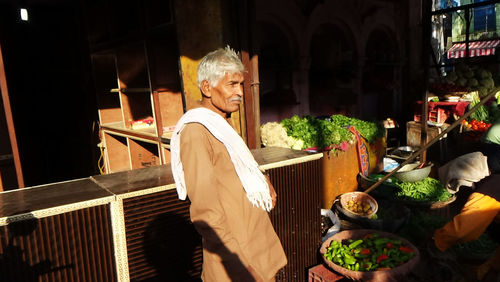 Side view of vendor standing at market stall