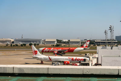 Airplane on airport runway against sky