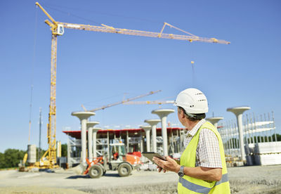 Worker on construction site using digital tablet