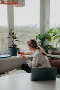 A young pretty woman in headphones communicates via video chat with mobile phone. high quality photo