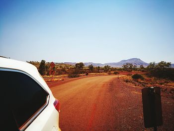 Road by mountain against clear sky